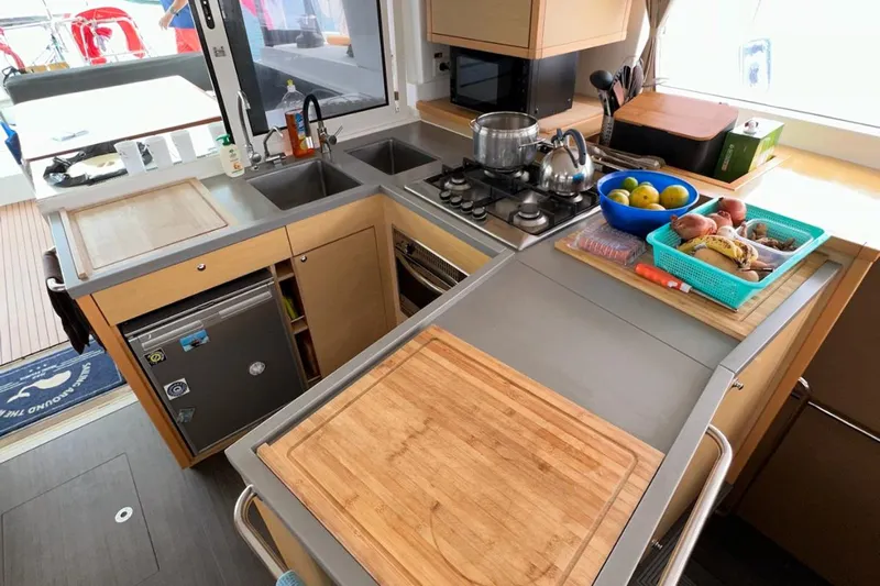 Sixtus Yacht Photos Pics Modern kitchen in a 2016 Lagoon 450 s yacht with stove, sink, and cutting boards.