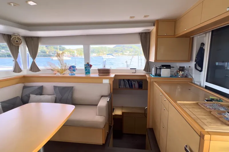 Sixtus Yacht Photos Pics Interior of 2016 Lagoon 450 s catamaran with dining area, windows, and wooden cabinetry.