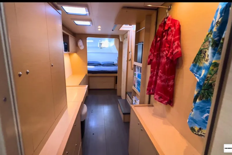 Sixtus Yacht Photos Pics Interior of 2016 Lagoon 450 s yacht, featuring cozy cabin with wooden furnishings and hanging clothes.