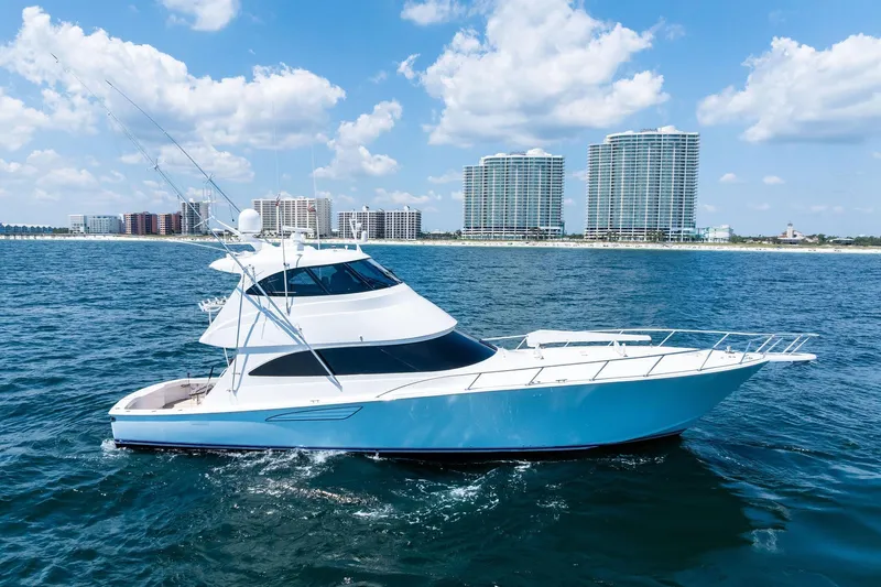 Sexy Lady Yacht Photos Pics 2017 Viking 62 Enclosed Bridge yacht cruising near coastal skyline.
