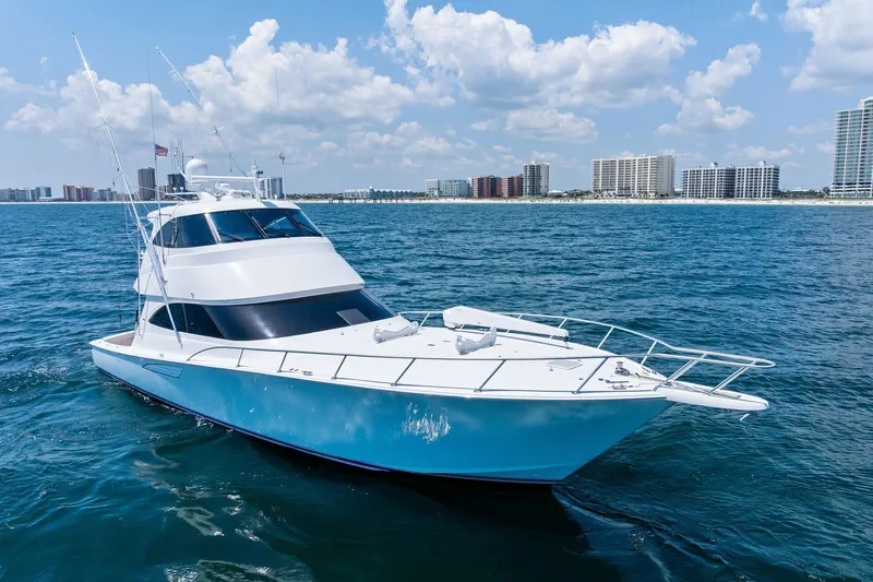 Sexy Lady Yacht Photos Pics 2017 Viking 62 Enclosed Bridge yacht cruising on ocean near city skyline.