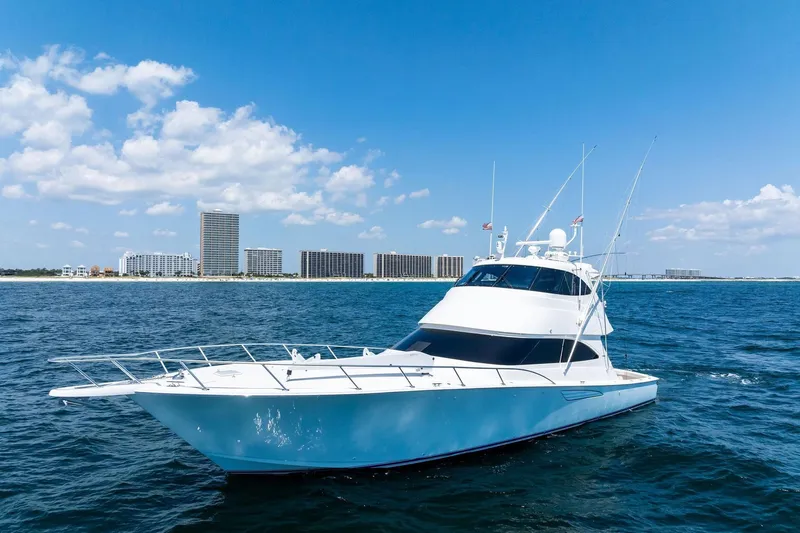 Sexy Lady Yacht Photos Pics 2017 Viking 62 Enclosed Bridge yacht on open water with city skyline backdrop.