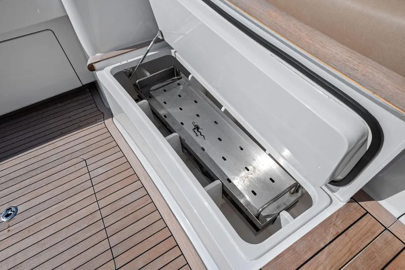 Sexy Lady Yacht Photos Pics Open storage compartment on 2017 Viking 62 Enclosed Bridge yacht with wooden deck.