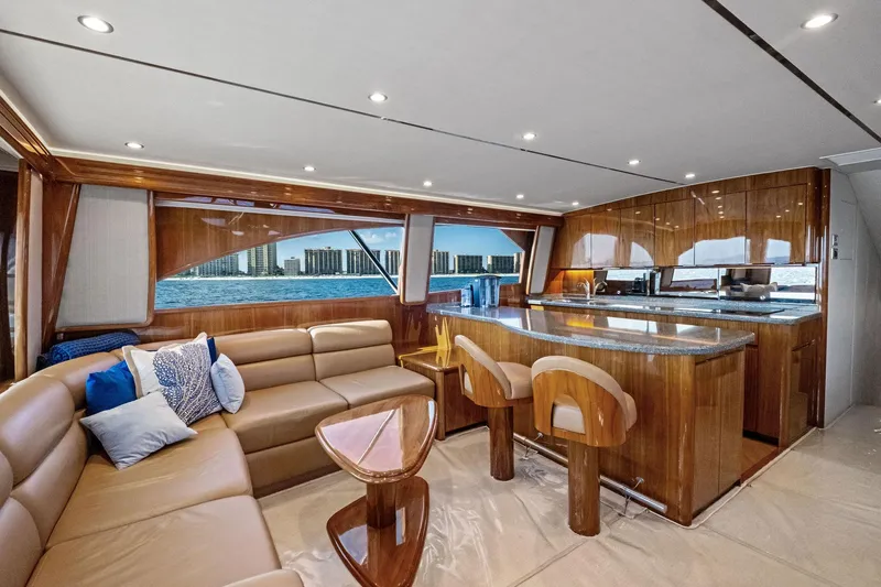 Sexy Lady Yacht Photos Pics Luxurious interior of 2017 Viking 62 Enclosed Bridge yacht with elegant seating and kitchen area.