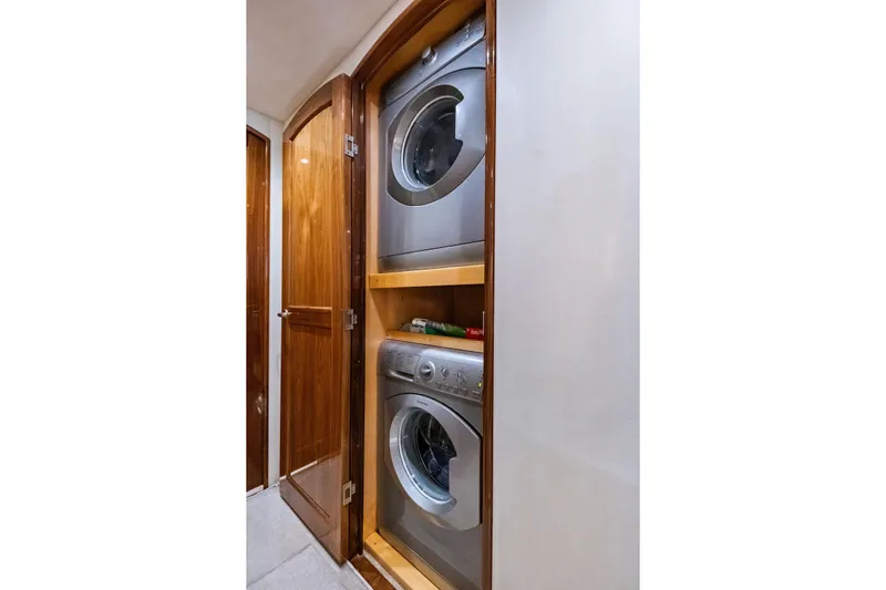 Sexy Lady Yacht Photos Pics Laundry area with stacked washer and dryer in 2017 Viking 62 Enclosed Bridge yacht.