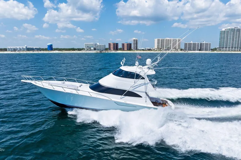 Sexy Lady Yacht Photos Pics 2017 Viking 62 Enclosed Bridge yacht cruising on ocean near city skyline.