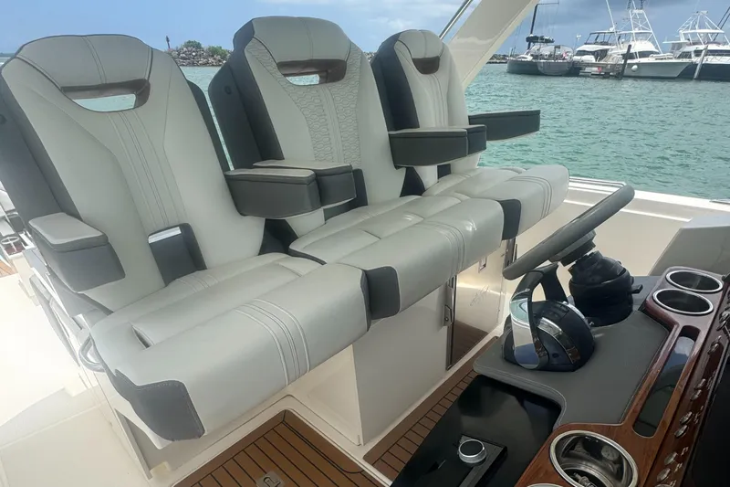  Yacht Photos Pics 2020 Tiara Sport 34 LS boat interior with luxury seating and steering wheel, docked by the water.