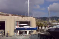 Custom IMS proto 33' sailboat from 1997 in a marina, with overcast sky.
