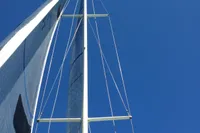Sailboat mast and sails against clear blue sky, Custom IMS proto 33', 1997.