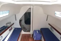 Interior of 1997 Custom IMS proto 33' sailboat with blue cushions and wooden flooring.