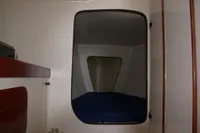 Interior cabin of 1997 Custom IMS proto 33' yacht with bed and storage.