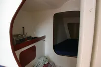 Interior of 1997 Custom IMS proto 33' sailboat with compact kitchen and sleeping area.