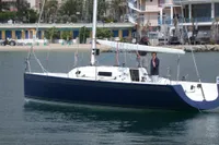 Sleek 1997 Custom IMS proto 33' sailboat docked in a scenic marina.