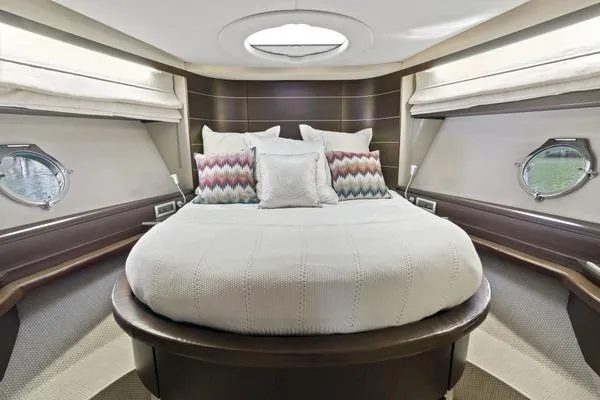 Yacht Photos Pics Luxurious bedroom interior of 2009 Azimut 68S yacht with round bed and porthole windows.