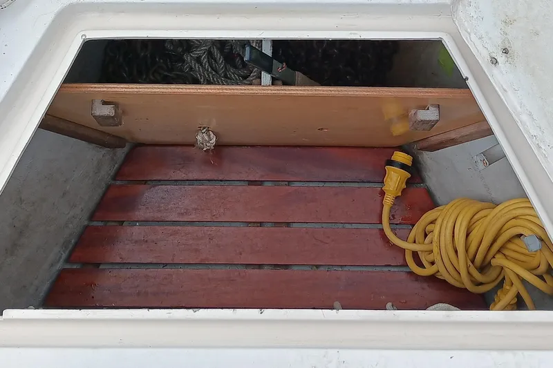 Rhythm Yacht Photos Pics Open storage compartment on 1991 Gozzard 31 boat with coiled yellow cable.