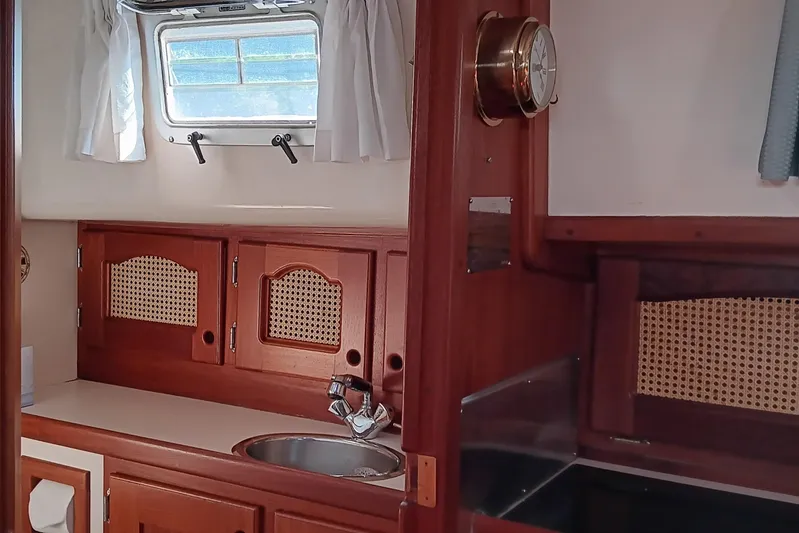 Rhythm Yacht Photos Pics Interior of 1991 Gozzard 31 sailboat with wooden cabinetry and porthole window.