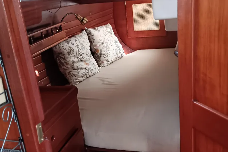 Rhythm Yacht Photos Pics Cozy cabin interior of 1991 Gozzard 31 sailboat with wooden finish and floral pillows.