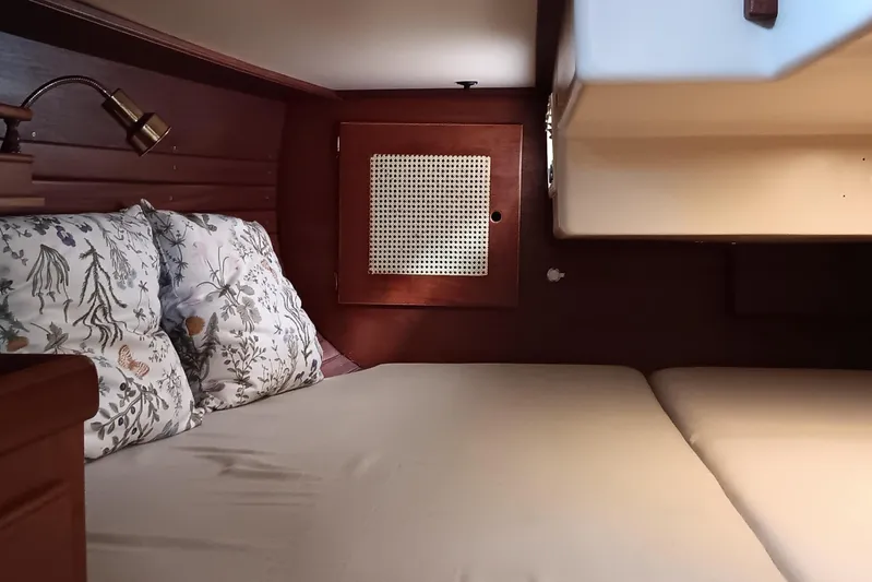 Rhythm Yacht Photos Pics Cozy cabin interior of 1991 Gozzard 31 sailboat with floral pillows and wooden accents.