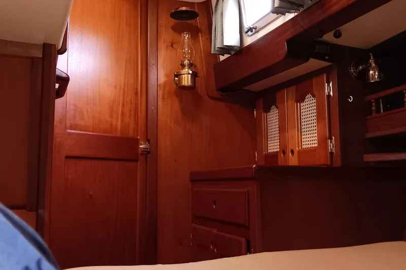 Rhythm Yacht Photos Pics Cozy wooden interior of a 1991 Gozzard 31 sailboat cabin with vintage lamp.