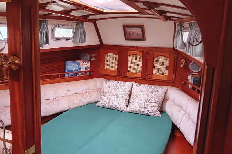Rhythm Yacht Photos Pics Cozy interior of 1991 Gozzard 31 sailboat with plush seating and wooden cabinetry.