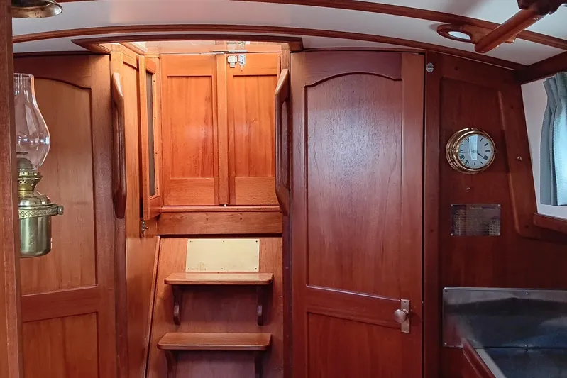 Rhythm Yacht Photos Pics Interior of 1991 Gozzard 31 sailboat with wooden cabinetry and brass clock.