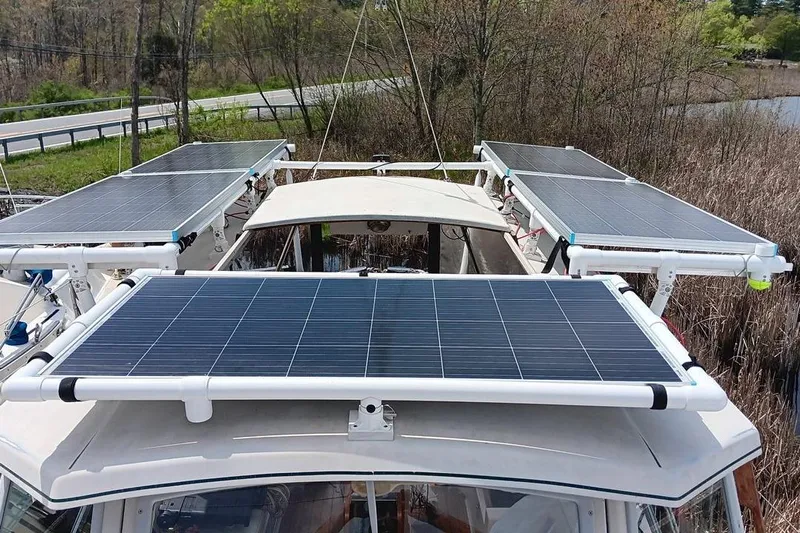 Rhythm Yacht Photos Pics Solar panels on a 1991 Gozzard 31 boat, surrounded by lush greenery.