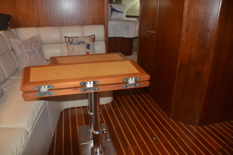 Sea Time Yacht Photos Pics Interior of 2001 Tiara Yachts 4100 Open with wooden table and cushioned seating.
