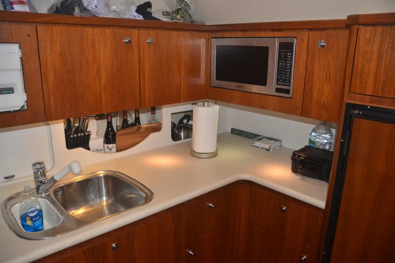 Sea Time Yacht Photos Pics 2001 Tiara Yachts 4100 Open galley with wood cabinets, sink, and microwave.