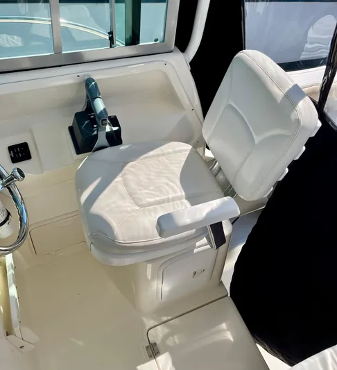 Empty Nest Yacht Photos Pics Captain's seat on 2012 Seaswirl Striper 2601 Walkaround boat, featuring white upholstery and control panel.