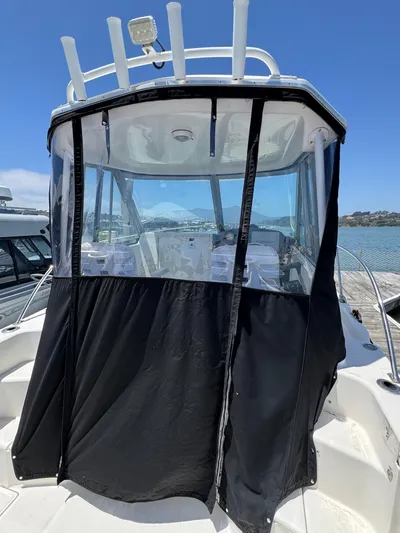 Empty Nest Yacht Photos Pics 2012 Seaswirl Striper 2601 Walkaround boat with black canvas enclosure, docked by the water.