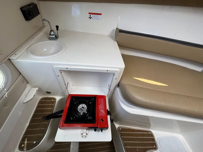 Empty Nest Yacht Photos Pics Interior of 2012 Seaswirl Striper 2601 Walkaround with sink, stove, and seating.
