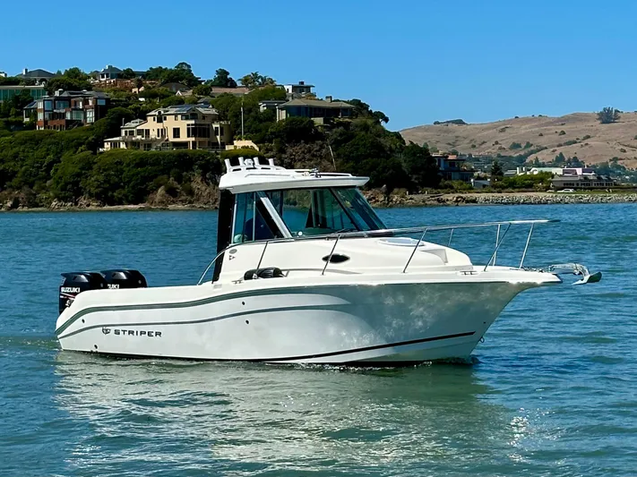 Empty Nest Yacht Photos Pics 2012 Seaswirl Striper 2601 Walkaround boat on water, with scenic coastal background.