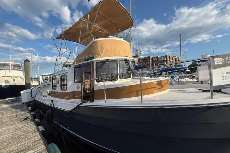  Yacht Photos Pics 2024 Ranger Tugs R31CB docked at marina under clear blue sky.