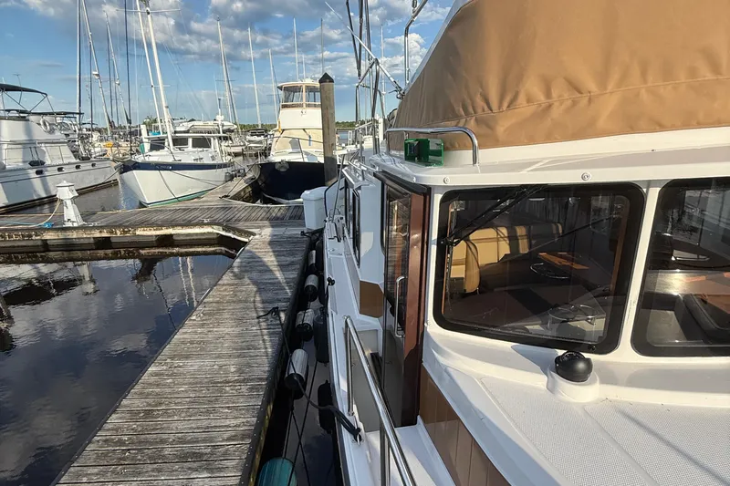  Yacht Photos Pics 2024 Ranger Tugs R31CB docked at marina, surrounded by other boats.