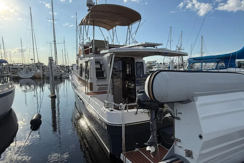  Yacht Photos Pics 2024 Ranger Tugs R31CB docked at marina, featuring upper deck and inflatable boat.