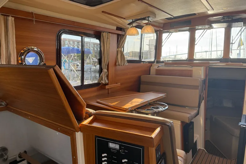  Yacht Photos Pics 2024 Ranger Tugs R31CB interior with wood finish, seating, and windows.