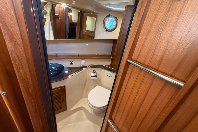 Yacht Photos Pics 2024 Ranger Tugs R31CB bathroom with wooden cabinetry and modern fixtures.