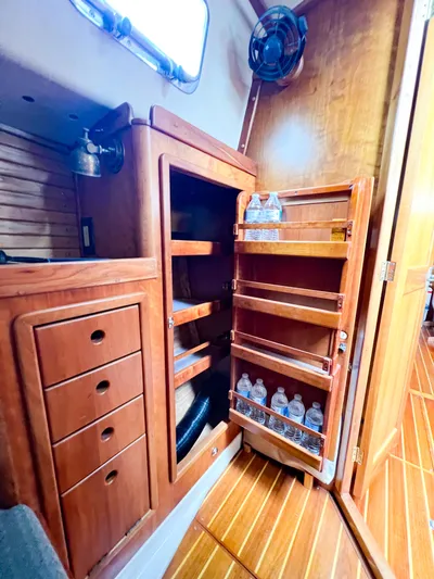 Alacrity Yacht Photos Pics Wooden interior of 1998 Saga 43 yacht with storage shelves and water bottles.