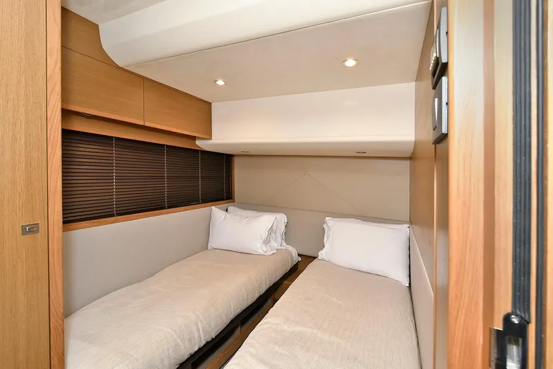"about Time" Yacht Photos Pics Twin cabin interior of 2016 Princess 52 Flybridge Yacht, featuring modern design and cozy bedding.
