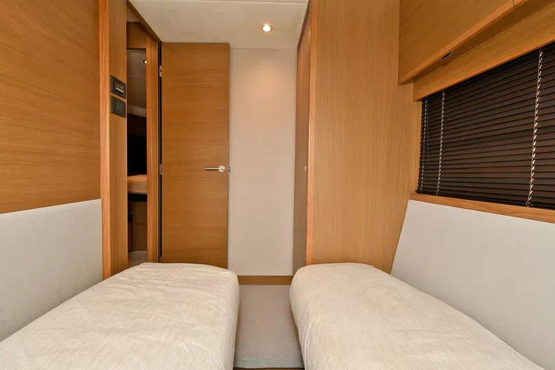 "about Time" Yacht Photos Pics Interior of 2016 Princess 52 Flybridge Yacht with twin beds and wooden finish.