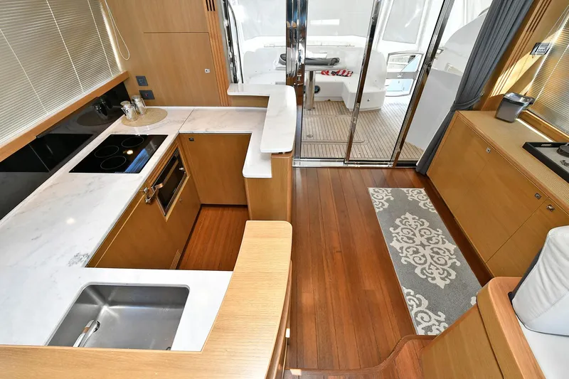 "about Time" Yacht Photos Pics Luxurious kitchen interior of 2016 Princess 52 Flybridge Yacht with modern amenities and wooden flooring.