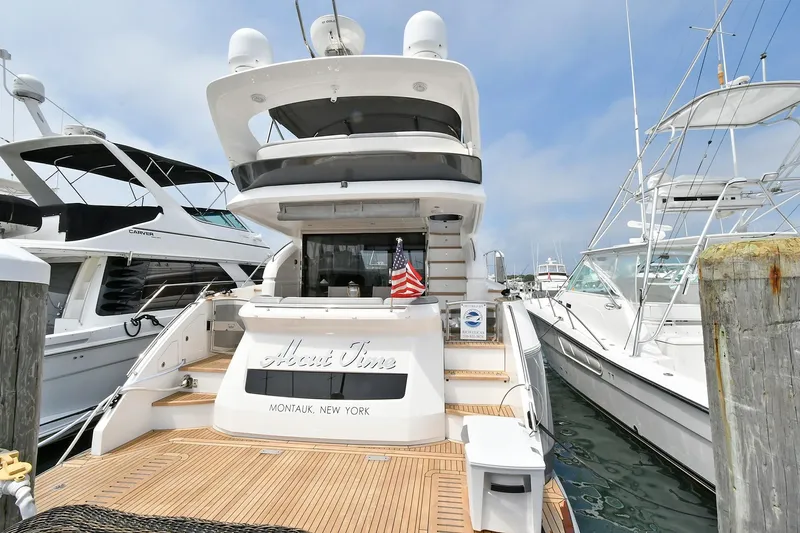 "about Time" Yacht Photos Pics 2016 Princess 52 Flybridge Yacht docked, featuring spacious deck and American flag.