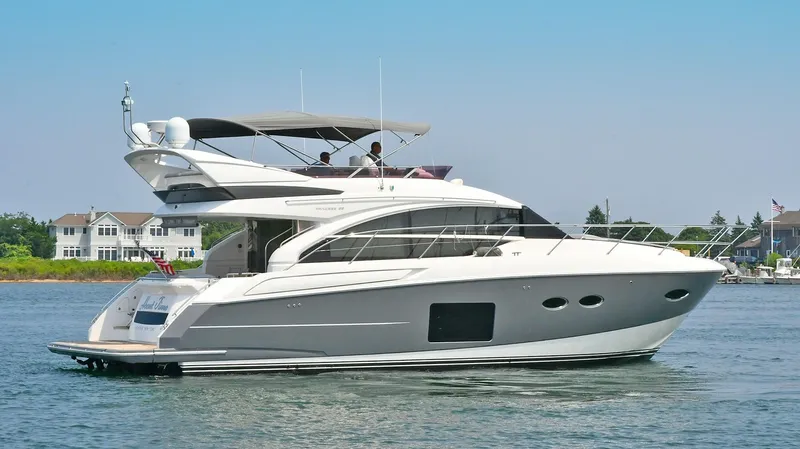 "about Time" Yacht Photos Pics 2016 Princess 52 Flybridge Yacht cruising on calm waters near residential area.
