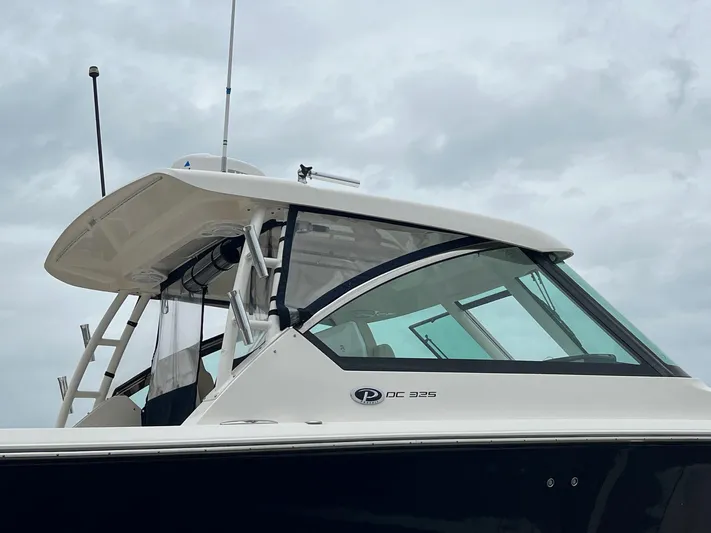 Hot Pursuit Yacht Photos Pics 2016 Pursuit 325 DC boat with sleek design against cloudy sky.