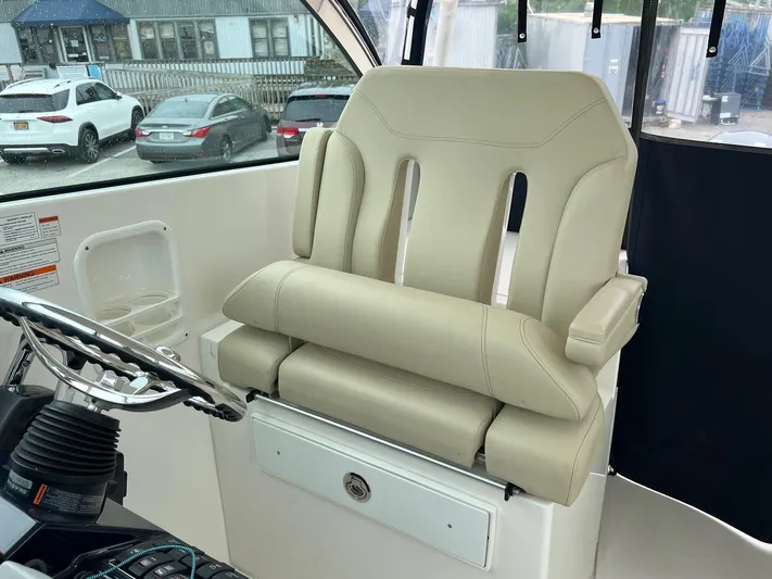 Hot Pursuit Yacht Photos Pics Captain's chair on 2016 Pursuit 325 DC boat, featuring beige upholstery and armrests.