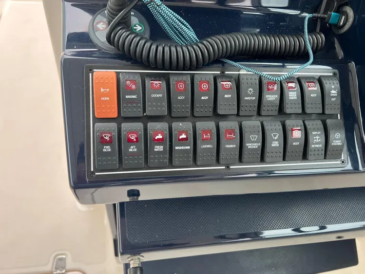 Hot Pursuit Yacht Photos Pics Control panel of a 2016 Pursuit 325 DC boat with various switches and buttons.