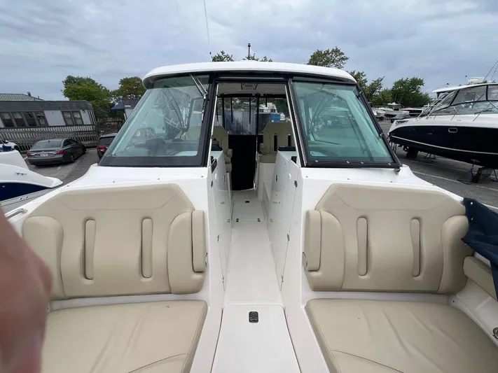 Hot Pursuit Yacht Photos Pics 2016 Pursuit 325 DC boat interior with beige seating, docked in a marina.