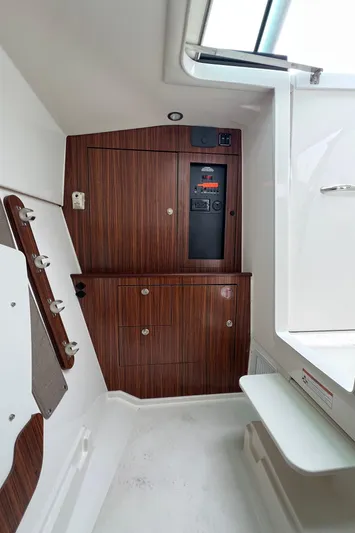Hot Pursuit Yacht Photos Pics 2016 Pursuit 325 DC cabin interior with wood paneling and control panel.