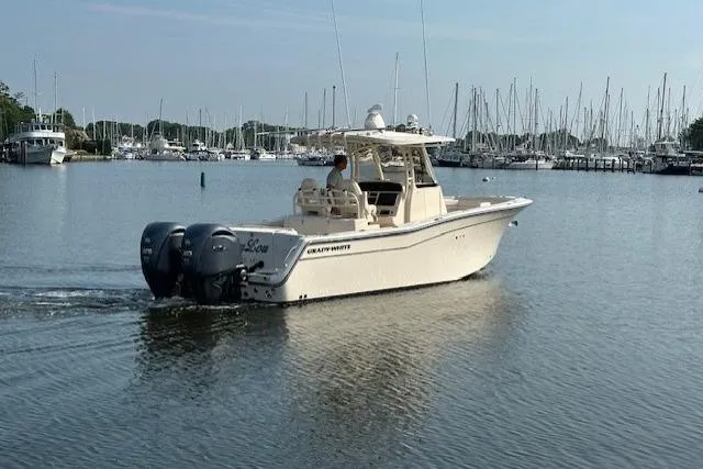  Yacht Photos Pics 2023 Grady-White Canyon 306 boat cruising in a marina with sailboats in the background.