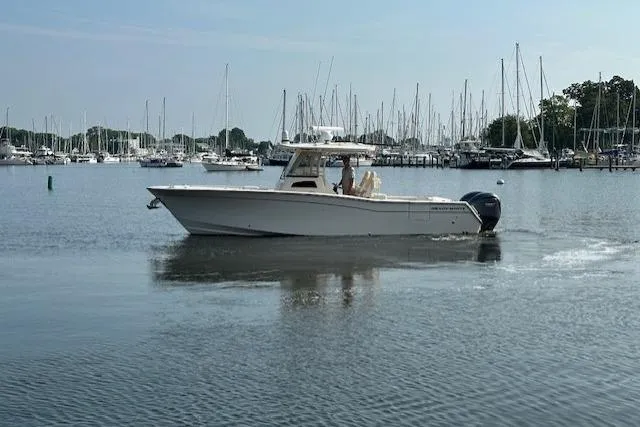  Yacht Photos Pics 2023 Grady-White Canyon 306 boat cruising in a marina with sailboats in the background.